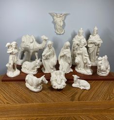 a group of white figurines sitting on top of a wooden table next to a wall