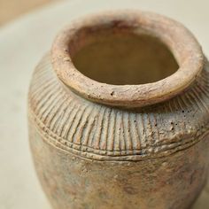 an old brown vase sitting on top of a table