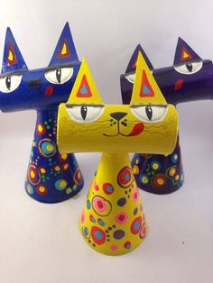 three colorful ceramic cats sitting on top of each other