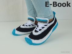 a pair of crocheted sneakers with white and black stripes