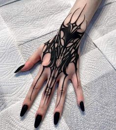 a woman's hand with black and white tattoos on it