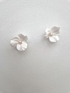 These lovely floral stud earrings are handcrafted with delicate polymer clay flowers and adorned with freshwater pearls. They are attached to sterling silver or gold-filled studs for a touch of elegance. Sent beautifully packaged in Medze Bride gift box. As 'Dreamy White' earrings are made to order as well due to hygienic reasons I cannot accept refunds/exchanges. But if you have any problems with your order please email me and I'll be happy to help you. Handle with care due to the handcrafted n Wedding Earrings Bride, Dreamy Whites, White Studs, Floral Studs, Bride Earrings, Minimal Wedding, Polymer Clay Flowers, Bride Gift, Clay Flowers