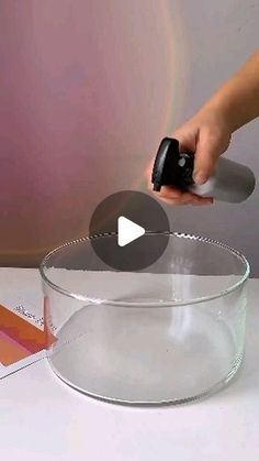 a person is using an object to make a cake in a glass bowl on a table