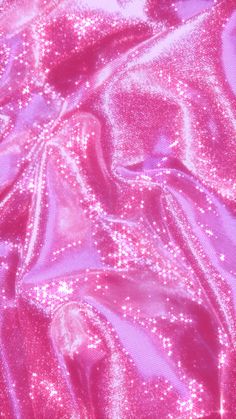 the fabric is shiny and pink with some sparkles on it's surface,