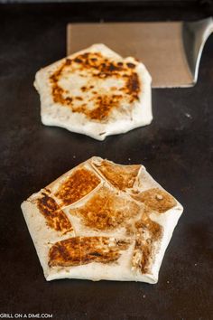 two pieces of pizza sitting on top of a counter