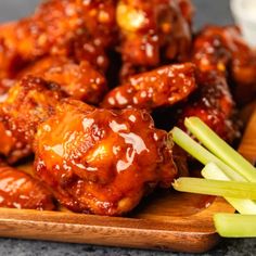 chicken wings with sauce and celery on a cutting board