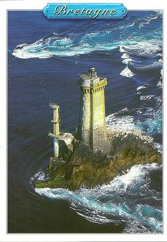 an aerial view of a lighthouse in the middle of the ocean with waves crashing around it