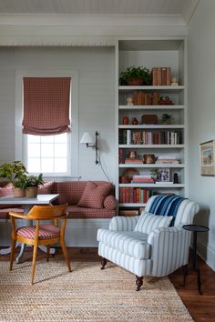 a living room filled with furniture and bookshelves next to a dining room table