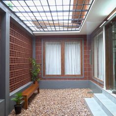 a room that has some plants in the corner and rocks on the ground underneath it