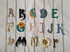 the letters are made out of different types of threads and appliqued