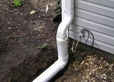 a white pipe is attached to the side of a house