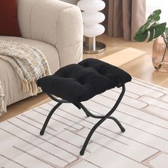 a black chair sitting on top of a white rug