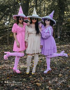 three women dressed up as witches in the woods