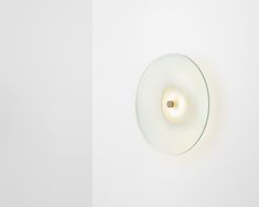 a white wall with a round light on it