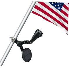 an american flag flying next to a metal pole with a camera on it's side