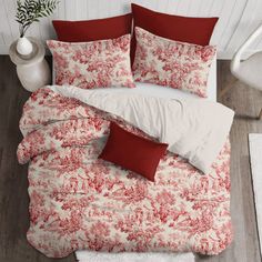 a bed with red and white pillows on top of it