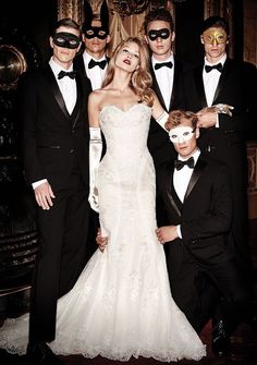 a group of people wearing masks and tuxedos