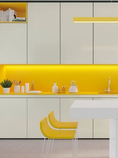 a modern kitchen with yellow lighting and white cabinets