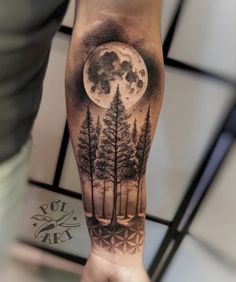 a man's arm with a full moon and trees tattoo on the left forearm