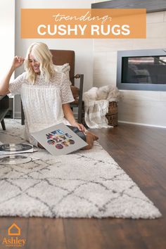 a woman sitting on the floor in front of a rug