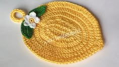 a crocheted lemon with a white flower on it