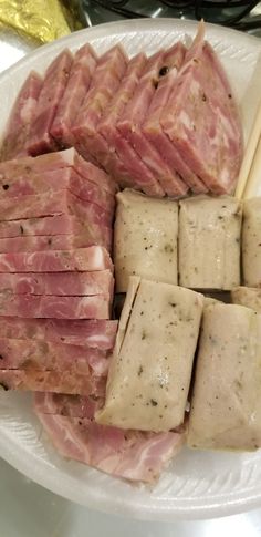 several pieces of meat on a plate with chopsticks next to it and another piece of cheese