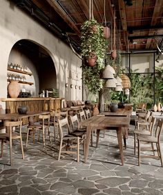 an outdoor dining area with wooden tables, chairs and potted plants hanging from the ceiling