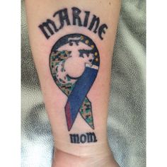 a marine mom tattoo on the wrist with a blue ribbon around it's neck