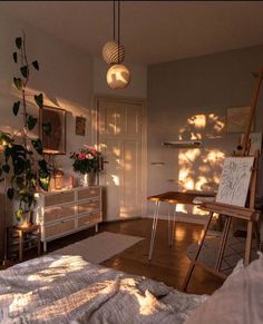 an artist's studio with sun shining through the windows and plants on the desk