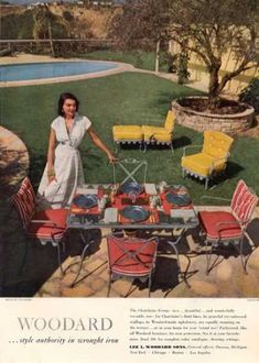 a woman standing in front of a table with chairs and an outdoor grill on it