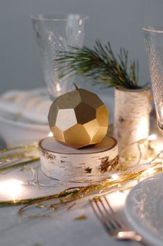 a table topped with white plates and gold decorations