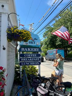 a woman standing next to a sign for bakery