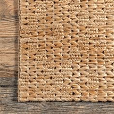 an area rug on top of a wooden floor with wood planks in the background