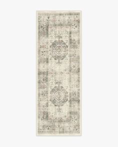 a white rug with an ornate design on the front and back side, in grey tones