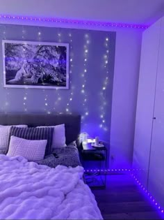 a bed room with a neatly made bed and purple lights on the wall above it