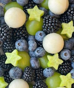 various fruits are arranged together on a plate with stars and berries in the middle one is white