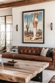 a living room filled with furniture and a painting hanging on the wall above it's coffee table