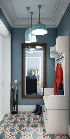 a bathroom with blue walls and patterned flooring is pictured in this image, there are two hanging lights above the mirror