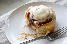 a white plate topped with a pastry covered in icing