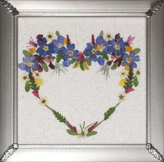 a heart shaped frame with blue and yellow flowers