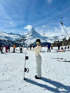 a woman is standing in the snow with her skis