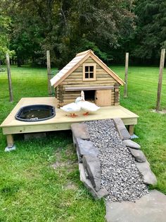 a duck house built on top of a wooden platform