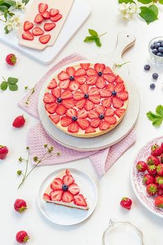 there is a pie with strawberries on it and blueberries in the shape of hearts