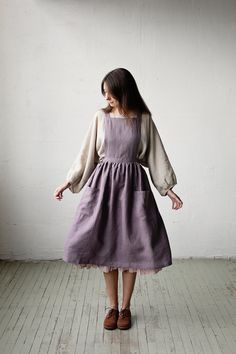 "Midi cross back pinafore is made from 100% soft and washed linen.  Details: - Colour: Mauve - Composition: 100% Oeko-Tex certified linen - Cross back - Adjustable with buttons - Size: One size - Medium weight linen - Linen care: machine wash gentle; tumble dry low, ironing optional - The price is for one pinafore dress, other pictured items are not included The model is 170 cm/5'7\" and wears a size one size." Apron Dress Outfit, Linen Pinafore Dress Pattern, Vintage Cotton Pinafore Dress For Spring, Cottagecore Pinafore, Spring Cottagecore Pinafore Dress, Linen Apron Pinafore, Linen Apron Dress, Purple Linen, Ruffle Apron