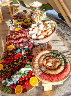 a table filled with different types of food on top of a wooden tablecloth covered floor