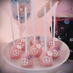 there are some cake pops decorated with peace signs on them and flowers in the middle