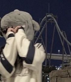 two people dressed in white are talking on their cell phones while one person is covering his face