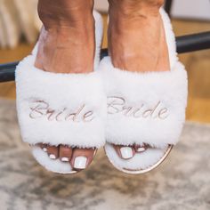 a close up of a person's feet wearing white slippers with the word bride written on them