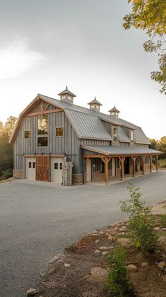 a large gray barn sitting on the side of a road