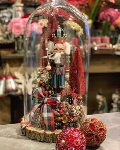 a nutcracker under a glass dome on a table with other ornaments and decorations